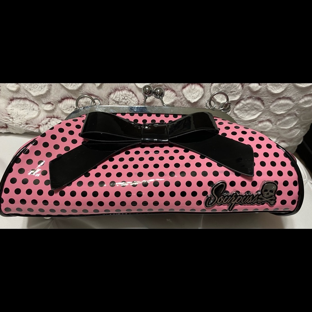 Sourpuss pink with black polka dot purse and a big black bow.